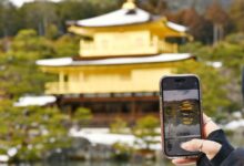 a person taking a picture of a building with a cell phone