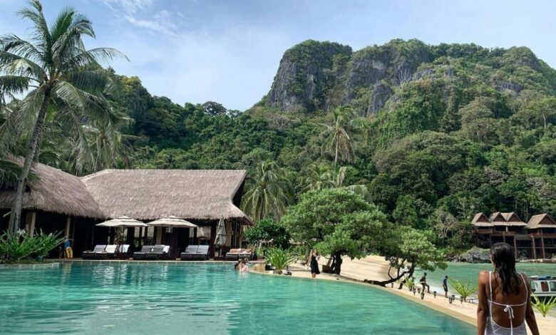 people walking on beach near green mountain during daytime